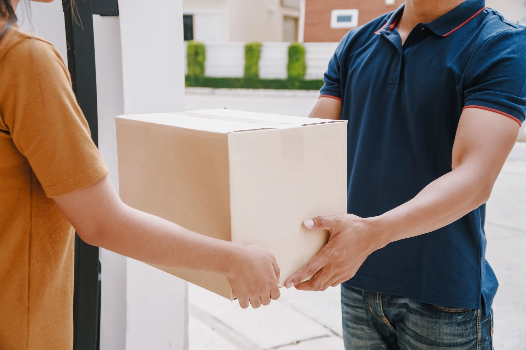 マンションで荷物を配達する男性スタッフ